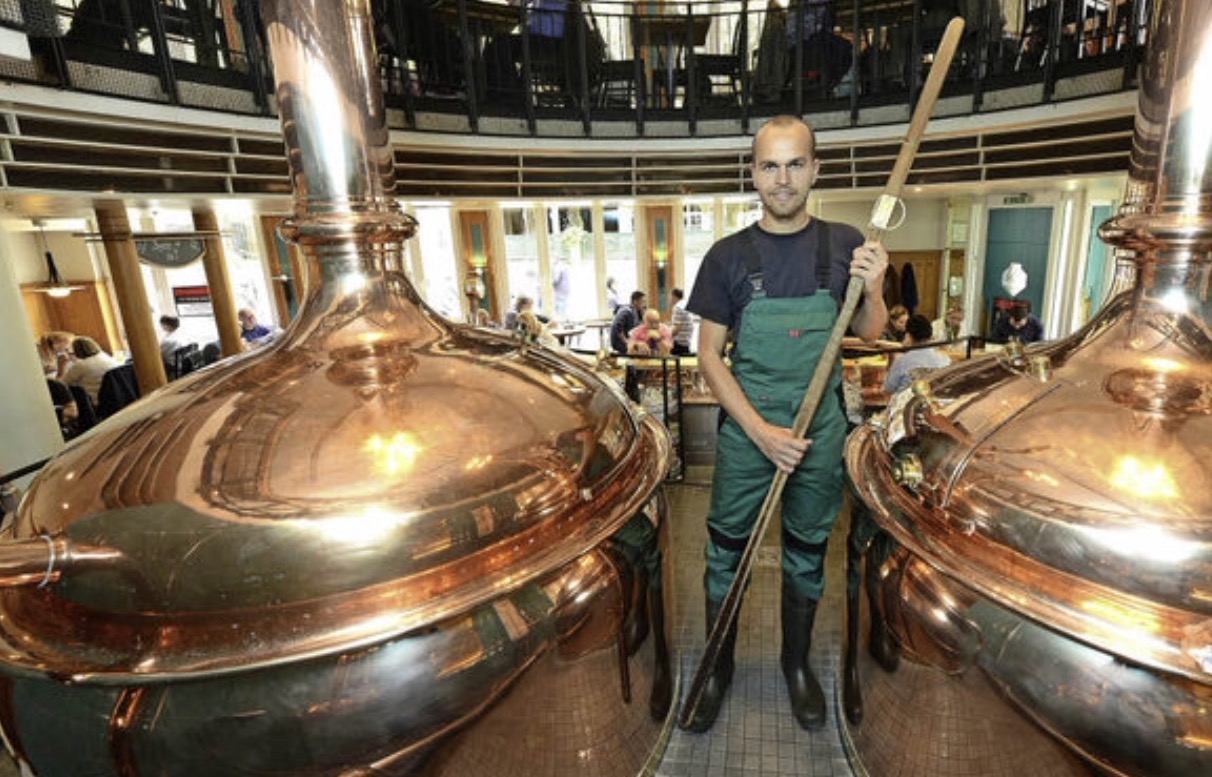 Gabriel Vierling an seinem Arbeitsplatz bei der Hausbrauerei Feierling: Mit dem Messstab in seinen Händen prüft er, wie hoch die Würze in den Kesseln steht. Foto: Ingo Schneider